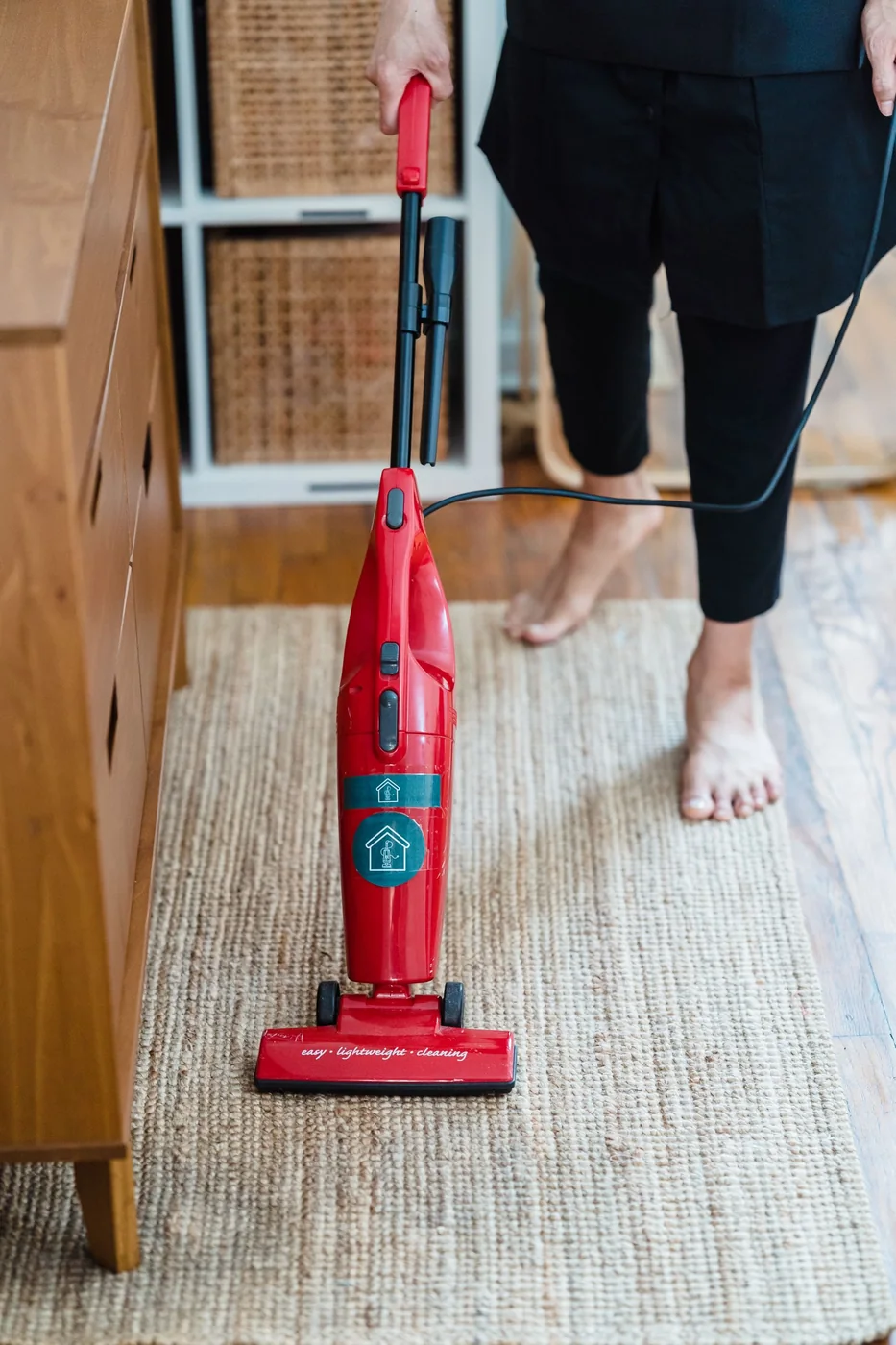 Vacuuming a carpet in a bright room.